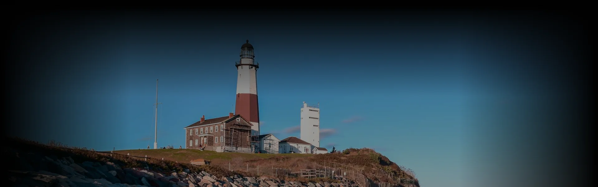 Luxury black car seen from a high angle as a chauffeur opens the door for a traveler on a New York to East Hampton ride.