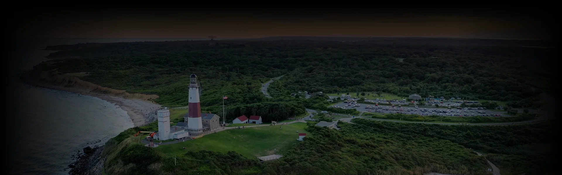 Overhead view of a chauffeur opening a black luxury sedan door for a passenger, illustrating a refined New York to Montauk transfer.